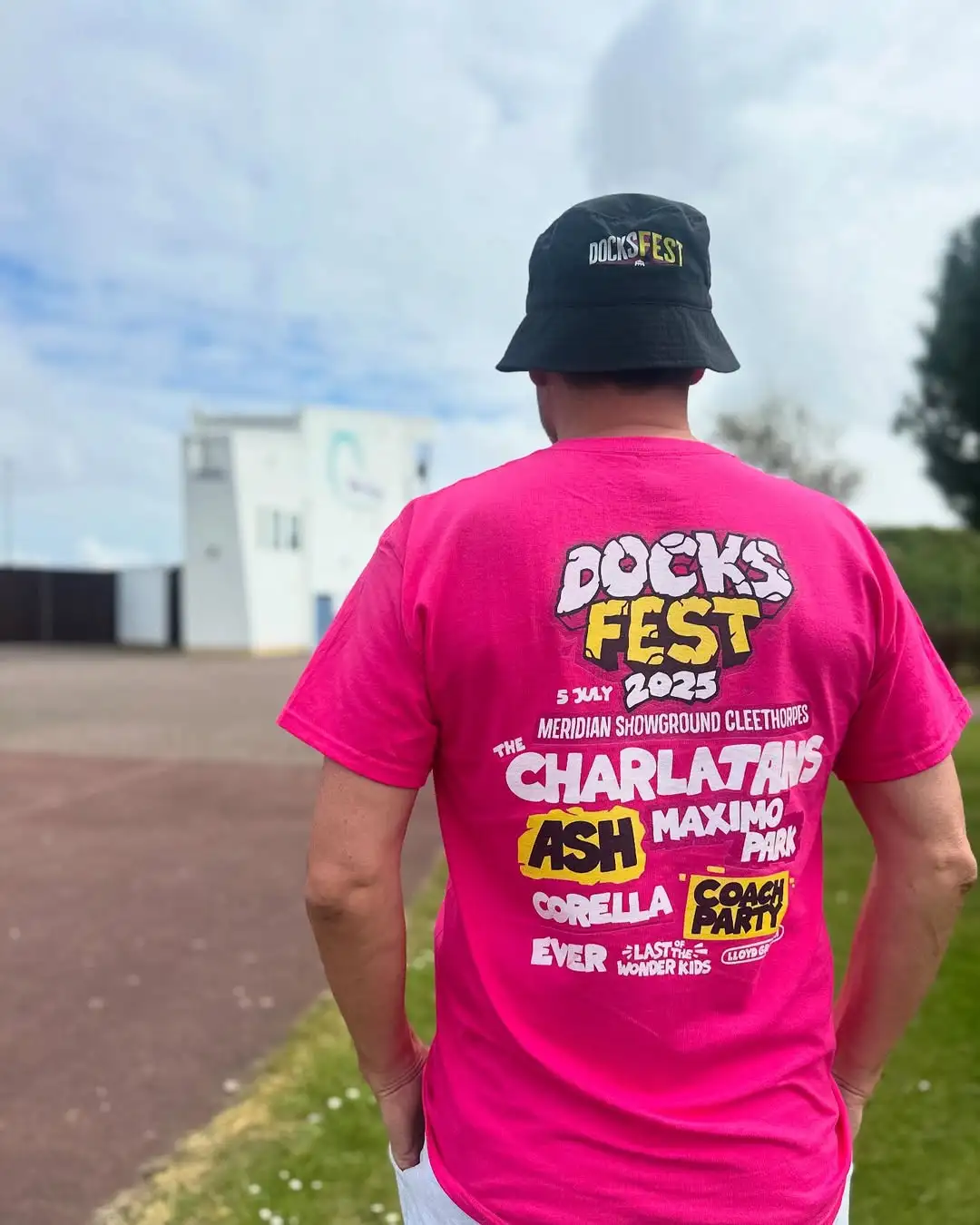 Man standing at Meridian Showground wearing a Docks Fest 2025 T Shirt and Bucket Hat with branding designed and illustrated by Sourcefour