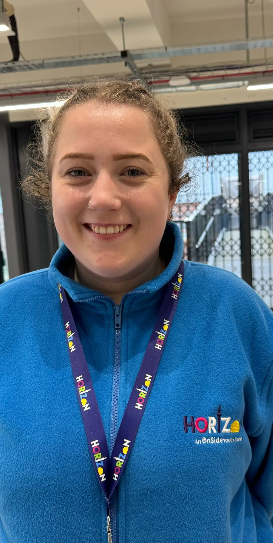 A lady wearing Horizon branded clothing and lanyard