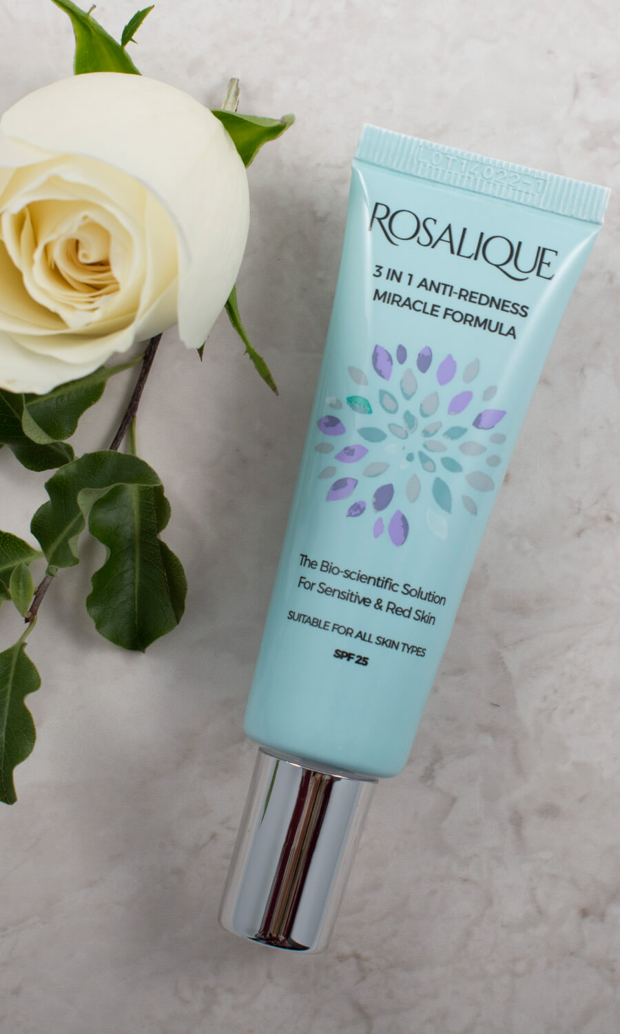 Rosalique Cream laid next to a flower
