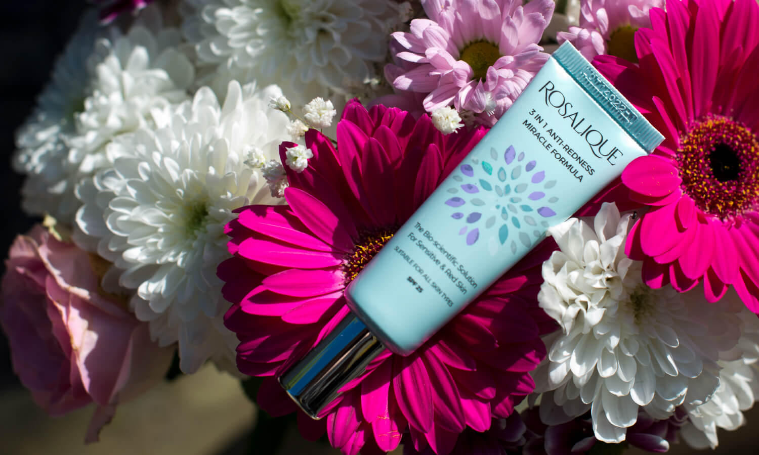 Rosalique 3 in 1 Anti-redness Cream laid on a bed of flowers