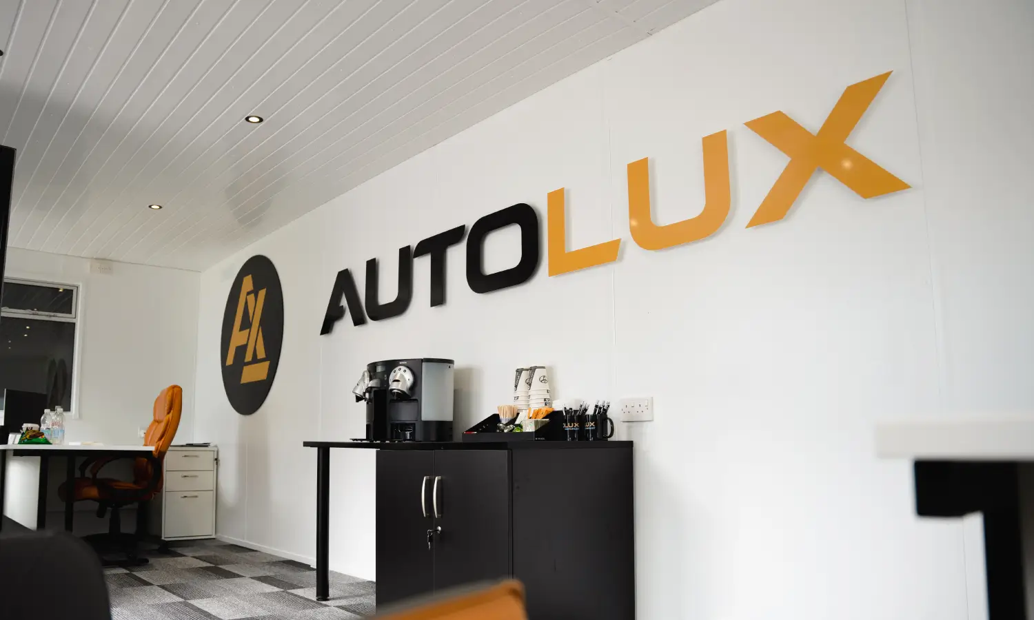 Big Autolux logo on a wall inside an office