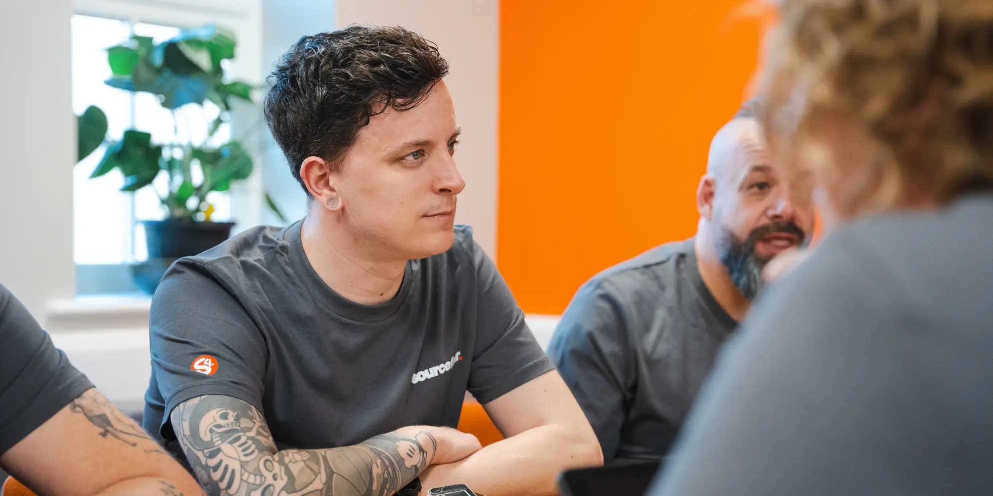 Kirk Arnold and Alex, Sourcefour employees, in deep discussion with the rest of the team