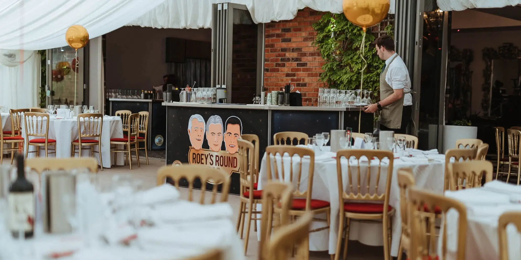 A tented wedding reception with tables and chairs.