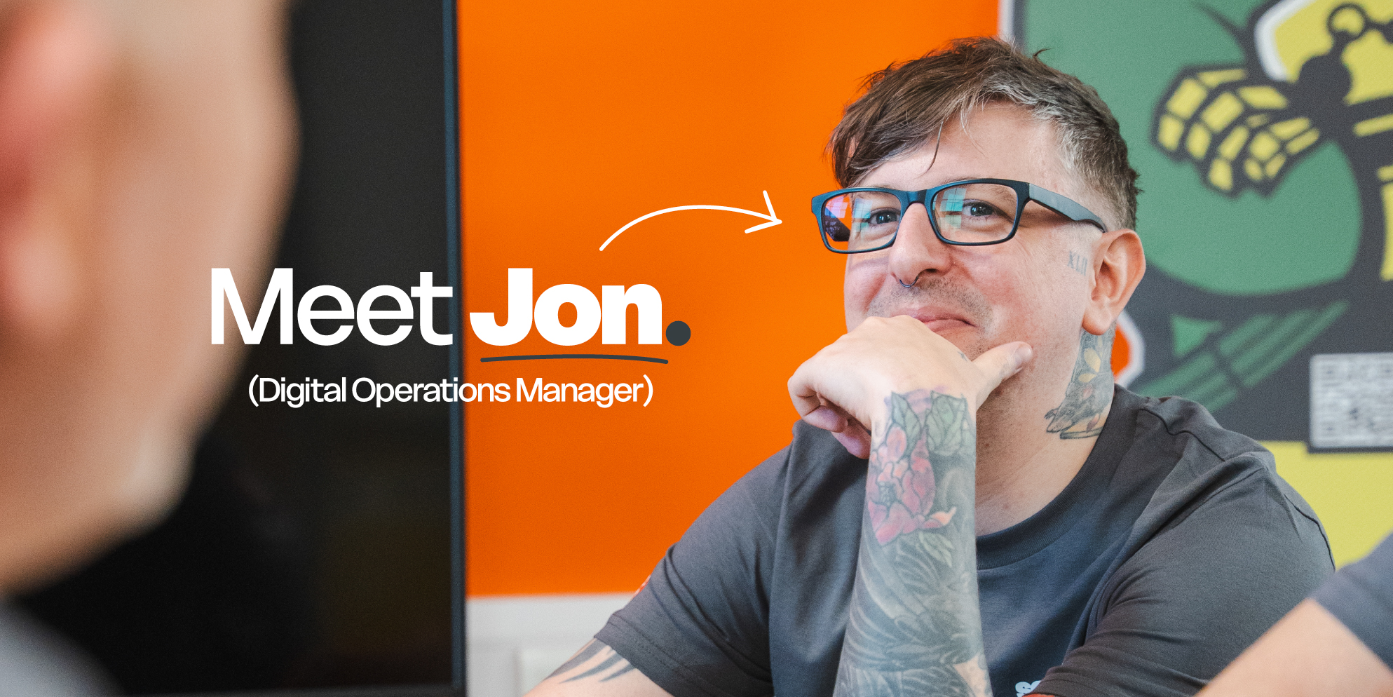 Meet the S4 Team - Sourcefour Digital Operations Manager Jon peeking over an orange room divider in the studio