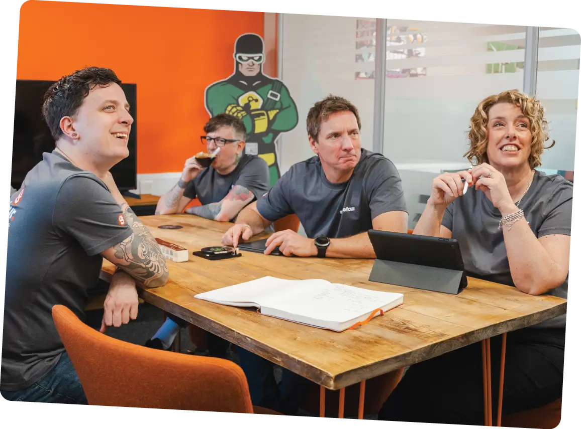 The Sourcefour team enjoy a meeting together, smiling and laughing