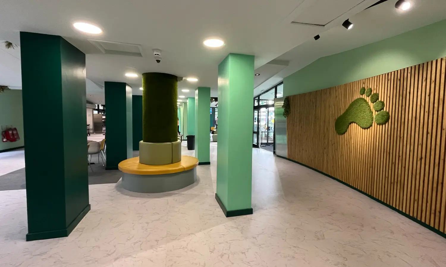 Hull College interior, featuring green walls in different shades and a grass foot
