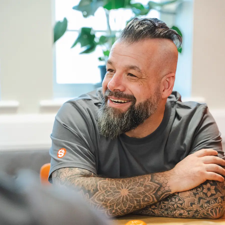 Alex, a Sourcefour employee, smiling and laughing in an office environment
