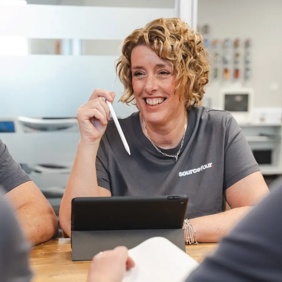 Alison, a Sourcefour employee, smiling, holding an apple pencil with an iPad